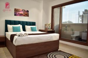 新德里Qotel Hotel Ashok Vihar Couple Friendly的一间带大床的卧室和一间浴室
