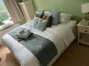 SurbitonThe Victorian Rooms的卧室配有带蓝色枕头的大型白色床