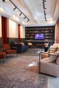 马德里LATROUPE Prado Hostel的带沙发和电视的大型客厅