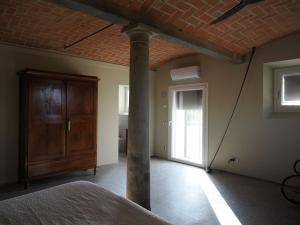FabbricoA chalet in the Italian countryside的一间设有天花板、柱子和门的房间
