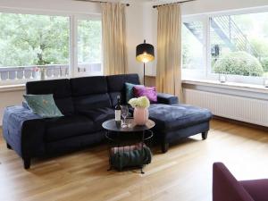 施马伦贝格Ferienwohnungen Familie Schauerte的客厅配有黑色沙发和桌子