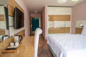 伯萨TOK EPİK HOTEL的一间卧室配有一张床和一张书桌及电视