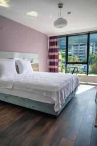 伯萨TOK EPİK HOTEL的一间卧室设有一张大床和一个大窗户