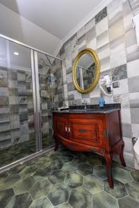 伯萨TOK EPİK HOTEL的浴室配有盥洗盆和带镜子的淋浴
