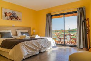 圣安东尼奥德阿雷科Un Alto en la Huella - Hotel Spa & Wellness Resort的一间卧室设有一张床和一个大窗户