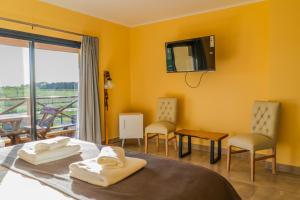 圣安东尼奥德阿雷科Un Alto en la Huella - Hotel Spa & Wellness Resort的客房设有1张床、1台电视和1个阳台。