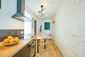 Veneux-les-SablonsAppartement standing à 7min de Fontainebleau centre, 3min de Moret-sur-Loing et 45min de Paris (1min à pied de la gare)的厨房配有带一碗水果的柜台