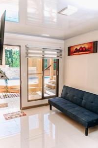 皮卡2 Cabañas para 5 Personas Oasis Pica-Matilla的客厅配有黑色沙发和滑动玻璃门