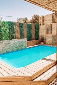 皮卡2 Cabañas para 5 Personas Oasis Pica-Matilla的一个带木制甲板和游泳池的游泳池