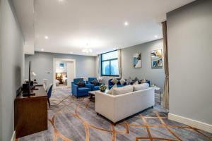 多哈فندق شراعوه الملكي - Luxury的客厅配有白色沙发和蓝色椅子