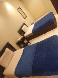 阿可贺巴سلسبيل للغرف المفروشة的两张位于酒店客房的床,配有蓝色枕头