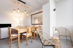 波瓦-迪瓦尔津Póvoa 3 Suites的一间带木桌和椅子的用餐室