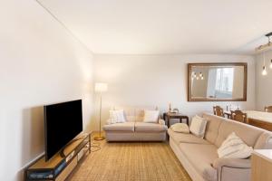 波瓦-迪瓦尔津Póvoa 3 Suites的带沙发和平面电视的客厅