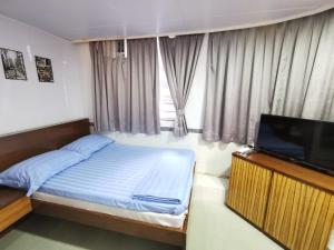 香港香港百乐宾馆 Best-B&B的一间卧室配有一张床和一台平面电视