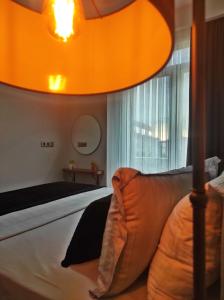 伊斯坦布尔SABIHA GOKCEN HOTEL İSTANBUL HOUSES的一间卧室配有一张床和一个大型橙色灯