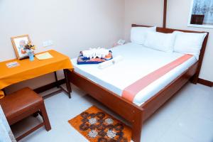 姆万扎Port Park Hotel的一间小卧室,配有一张床和一张桌子