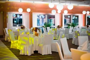 格但斯克Hotel Platan的宴会厅配有白色的桌子和黄色的椅子