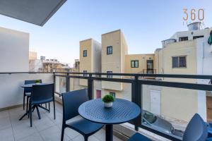 马尔萨斯卡拉A lovely 2BR home with a private balcony by 360 Estates的阳台的天井配有桌椅