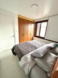 本图贡萨尔维斯Apartamento Artístico - Garagem - Ar Condicionado - Excelente Localização的一间卧室配有一张大床和枕头