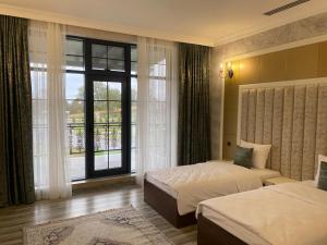 盖贝莱Nohur Hotel Gabala的酒店客房设有两张床和大窗户。