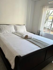 LobatseSwinburn’s Rest的卧室配有一张带白色床单的大床和窗户。