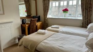 温彻斯特The Cricketers Inn的酒店客房设有两张床和窗户。