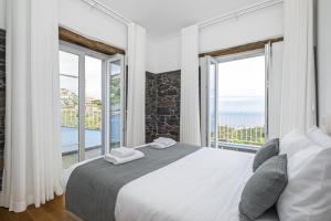 蓬他达维托亚Casas da Luz by Madeira Sun Travel的一间卧室设有一张大床和大窗户