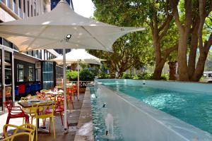 开普敦Fountains Hotel的一个带桌椅的游泳池以及遮阳伞