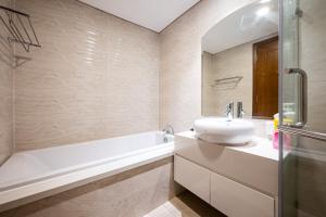 胡志明市LANDMARK PLUS RESIDENCES LUXURY SUITE的浴室配有盥洗盆、浴缸和盥洗盆