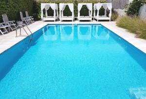 埃斯特角城Atlántico Boutique Hotel的一个带椅子的游泳池和蓝色的游泳池