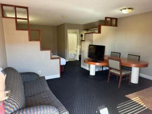 圣安东尼奥圣安东尼奥霍姆盖特一室公寓及套房酒店的客厅设有书桌、电视和楼梯。