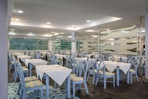 阿瓜杜尔塞Hotel Portomagno by ALEGRIA的一间设有白色桌椅的用餐室