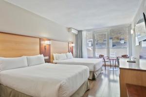 安道尔城安道尔中心最佳酒店 的酒店客房设有两张床和一张桌子。