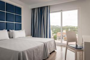 罗列特海岸ALEGRIA Sun Village的酒店客房设有一张床和一个大窗户