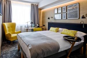 卢布林地区托马舒夫B&B HOTEL Tomaszów Lubelski的酒店客房,配有床和黄色椅子