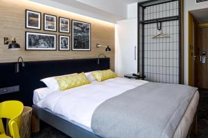卢布林地区托马舒夫B&B HOTEL Tomaszów Lubelski的卧室配有一张带黄色枕头的大型白色床。