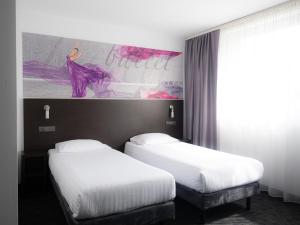 比托姆B&B HOTEL Bytom的两张位于酒店客房的床,墙上挂着一幅画
