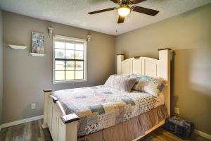 查尔斯湖Charming Lake Charles Home with Patio and Grill的一间卧室配有一张带吊扇的床