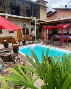 伊利亚贝拉Guest House Della Vita的一座带红伞的房子前的游泳池