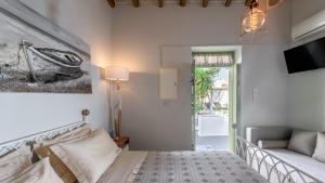 阿波罗尼亚villa lord的一间卧室配有一张床、一张沙发和一台电视。