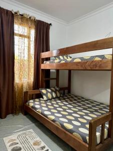 阿鲁沙Homestay in Arusha Wanderful Escape的一间卧室设有两张双层床和一扇窗户。