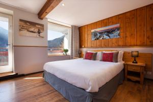 夏蒙尼-勃朗峰Chalet Hôtel La Sapinière的一间卧室配有一张带木镶板的大床