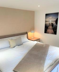 赛巴特班森Moderner Bungalow im Seebad Bansin, 200 Meter zum Strand的卧室配有白色大床和灯