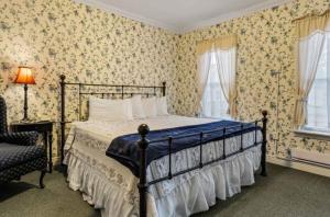 普莱西德湖普莱西德湖村派恩斯旅馆的壁纸客房内的一间卧室配有一张床