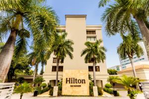 圣萨尔瓦多Hilton San Salvador的前面有棕榈树的酒店
