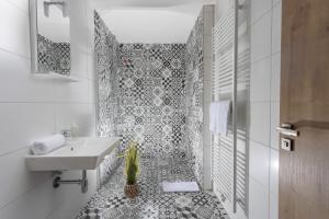 马达伯乐斯拉夫Residence Morris Mladá Boleslav的浴室设有白色水槽和黑白瓷砖。