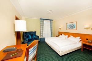 格赖夫斯瓦尔德科隆普林兹酒店的配有一张床和一张书桌的酒店客房