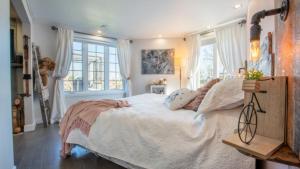 霍克斯伯里Waterfront Oasis Luxury Retreat Between Ottawa and Montreal的卧室配有一张带白色床单和枕头的大床。