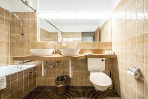 武尔佩拉PL 202 Lichtdurchflutete Wohnung mit grossem Balkon Richtung Scuol的浴室配有2个盥洗盆、卫生间和浴缸。