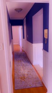 博克斯堡OR Tambo Airport Mansion/self catering/Holiday hme的走廊上设有蓝色的墙壁和地毯